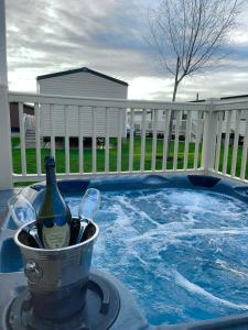 塔特舍尔Luxury Hot Tub Caravan Tattershall的热水浴池旁的桶装葡萄酒和玻璃杯