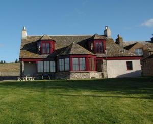 LatheronCraiglea Lodge的绿色草坪上带红色窗户的大房子
