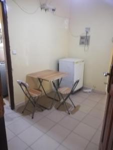 达喀尔Buzsahm的厨房配有桌子、两把椅子和冰箱