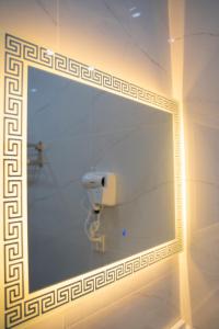 巴哈瓦尔布尔The Edition Bahawalpur的浴室内的镜子,配有卫生纸饮水机