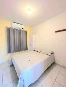 巴拉多库努Chalés Sons do Mar的卧室配有一张大白色床和窗户