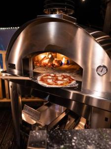 Pont Sticill3 - Spectacular Views - Pizza Oven & BBQ的正在比萨饼烤箱里烤制比萨饼