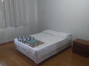 巴西利亚Hospedaria Chaves的一张小床,位于带桌子的房间