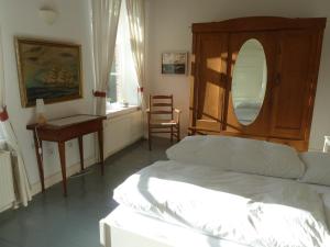 迪楚姆Hof Homfeld的一间卧室配有一张床、一张桌子和一面镜子