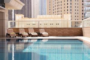 迪拜Marina One Bedroom - KV Hotels的一组椅子坐在游泳池旁