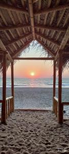 戈卡尔纳The Meraki Beach Resort的海滩凉亭的日落美景