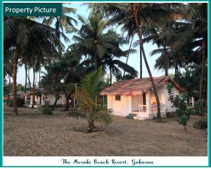 戈卡尔纳The Meraki Beach Resort的棕榈树海滩上的房子