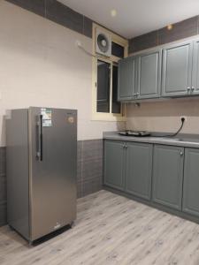 艾卜哈نيو العرين بارك أبها的厨房配有灰色橱柜和冰箱
