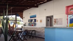 萨尔瓦多FAROL BEACH Suítes的一间带桌椅和柜台的餐厅