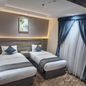 麦地那Jawharat Alia Apartment的酒店客房设有两张床和窗户。