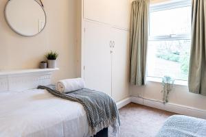 切斯特2 bed, up to 6 guests near Chester City Centre的一间卧室配有一张床、镜子和窗户