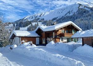 里茨勒恩Ferienwohnung Jochum-Pfeiffer的山前雪覆盖的房子