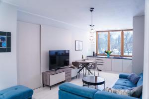 科希策Apartments Letná, AC & garage 89m2 and 44m2的客厅配有蓝色的沙发和桌子