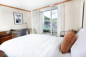 利斯塔尔Hotel Engel Business & Lifestyle的一间卧室配有一张床、一张书桌和一个窗户。