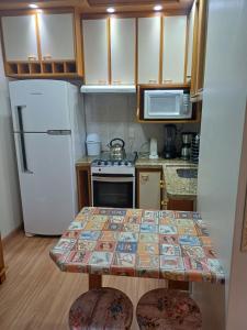 卡庞达卡诺阿Ap dos primos的一间带桌子和冰箱的小厨房