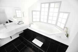 利斯塔尔Hotel Engel Business & Lifestyle的白色的浴室设有浴缸和水槽。