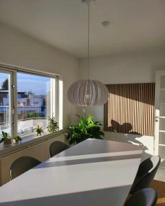 VibyModerne villalejlighed på 110 kvm + stor terrasse的一间带桌椅和大窗户的用餐室