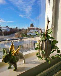 VibyModerne villalejlighed på 110 kvm + stor terrasse的一只小猫像和一株窗台上的植物