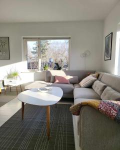 VibyModerne villalejlighed på 110 kvm + stor terrasse的客厅配有沙发和桌子