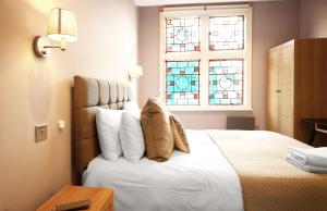 艾纯查姆Old Market Apartments的卧室配有带枕头的床铺和窗户。