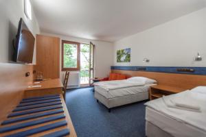 KurdějovHotel Kaskáda Kurdějov - Bed and Breakfast的酒店客房设有两张床和电视。