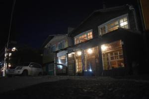 卡斯特鲁Estación Hostel的夜晚在房子前面停车的房屋