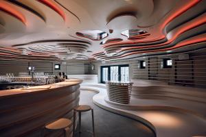 汉堡Villa Viva Hamburg的餐厅内的酒吧设有木制天花板和凳子