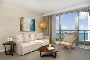 圣胡安Casa Costera, Isla Verde Beach, Apartments by Marriott Bonvoy的客厅配有沙发和椅子