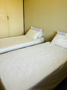 德班Gardenlea的两张睡床彼此相邻,位于一个房间里