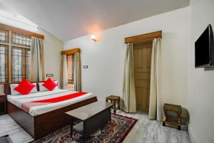 杜尔加布尔OYO Retro Residency的一间卧室配有一张带红色枕头的床和电视。