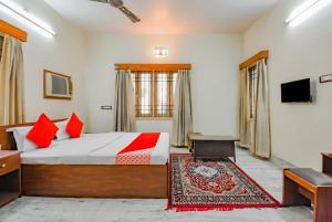 杜尔加布尔OYO Retro Residency的一间卧室配有一张带红色枕头的大床