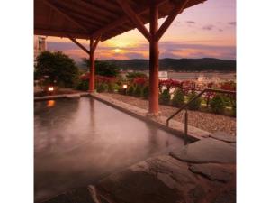 气仙沼市Kesennuma Plaza Hotel - Vacation STAY 15381v的一座享有日落美景的游泳池