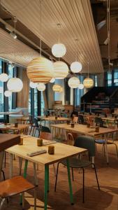 汉堡Villa Viva Hamburg的餐厅设有木桌和椅子及灯