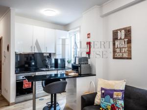 波尔图Alberti's House Oporto Central Apartment的客厅设有带黑色台面的厨房