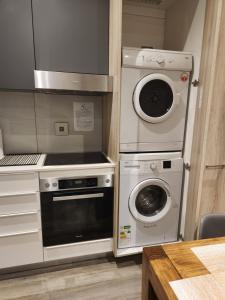 比勒陀利亚Stunning Apartment in The Capital Trilogy Menlyn Maine Residences - Apartment 721的厨房配有炉灶和洗衣机。