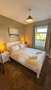 克利索普斯Sandy Shores Holiday Home的卧室配有一张大白色床和窗户