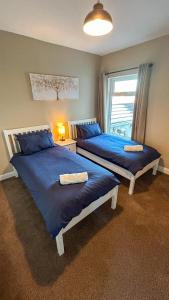 克利索普斯Sandy Shores Holiday Home的带窗户的客房内的两张床