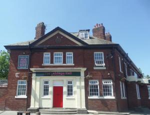 利物浦卡巴格大厅酒店的一座旧砖砌的建筑,设有红门