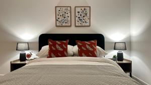 哈特菲尔德Superb & Stylish - Free Parking - Gated Community的一间卧室配有一张带红色枕头的床和两盏灯。