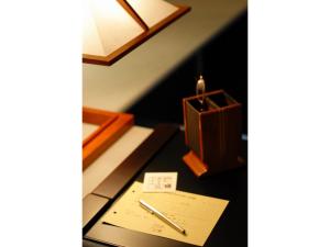 大仙市Tamachi Bukeyashiki Hotel - Vacation STAY 20163v的一张带蜡烛、笔和纸的桌子