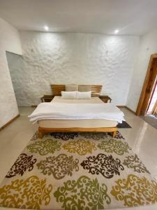 兰纳加Mandaal Corbett的一间卧室配有一张床和一张大地毯