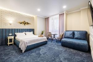 伊万诺-弗兰科夫斯克ApartReserve Avtorskiy的酒店客房,配有床和蓝色的沙发