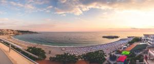 多布拉沃达度斯公寓酒店的享有海滩美景,配有遮阳伞和海洋美景。
