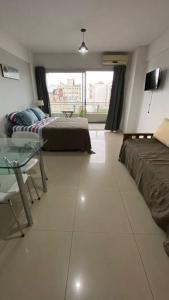 布宜诺斯艾利斯Estudio San Telmo的一间卧室配有一张床、一张桌子、一张床和一个窗户。