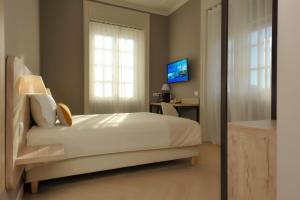 贝加莫Bergamo Inn 43的一间卧室配有一张床、一张书桌和一台电视