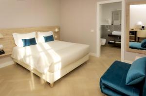 贝加莫Bergamo Inn 43的卧室配有带蓝色枕头的大型白色床