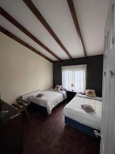 纳塔列斯港SHEUEN PATAGONIA的客房设有两张床和窗户。