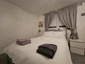 伦敦Stunning 1-Bed Apartment in London的卧室配有白色的床和2条毛巾