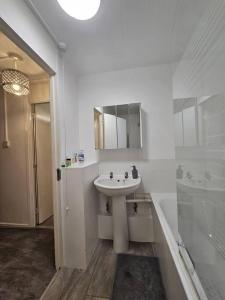 伦敦Stunning 1-Bed Apartment in London的白色的浴室设有水槽和浴缸。