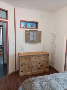 比桑Marguerite的一间卧室设有木制橱柜和窗户。